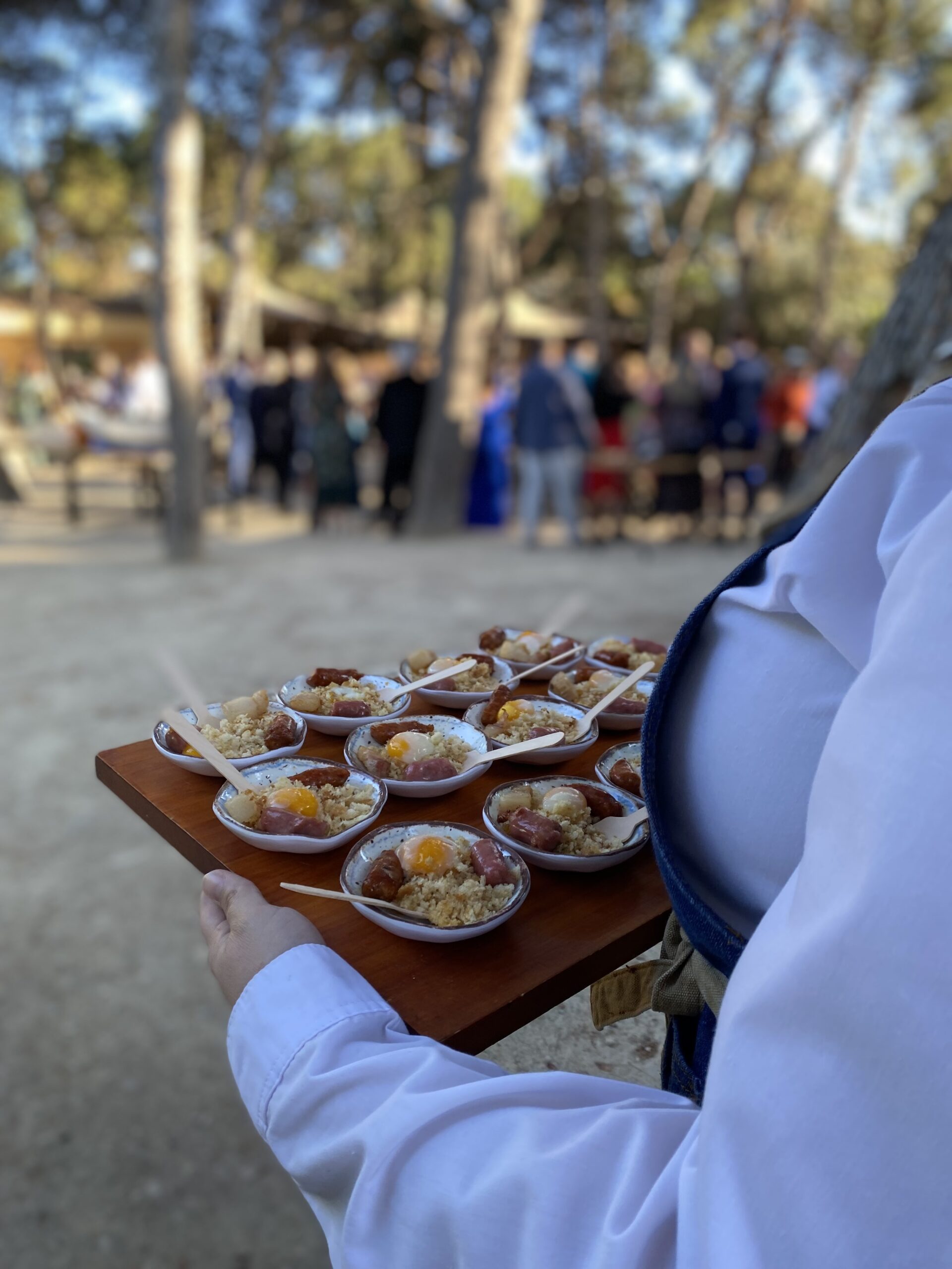 Camarera de servicio de catering con bandeja de aperitivos.